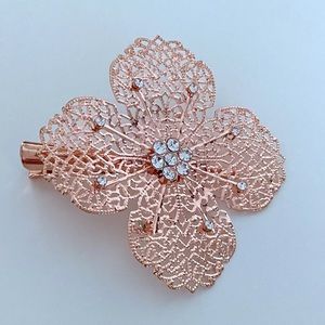 Lacy rose gold metal flower hair clip with rhinestones.